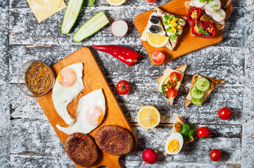 Variety of open sandwiches with different toppings on white backdrop