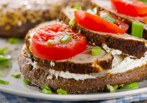 Grain bread sandwich with turkey, tomatoes and herbs.