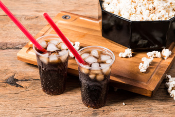 Popcorn and cola drink on wooden background