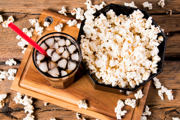 Popcorn and cola drink on wooden background