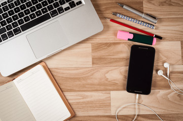 Picture of School and office supplies over office table with mobile and ear phone
