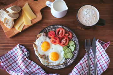 Breakfast of scrambled eggs with vegetables , bread and coffee