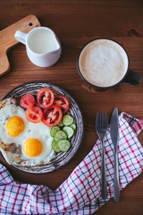 Breakfast of scrambled eggs with vegetables , bread and coffee