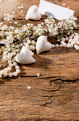 flowers, heart and perls on wooden background
