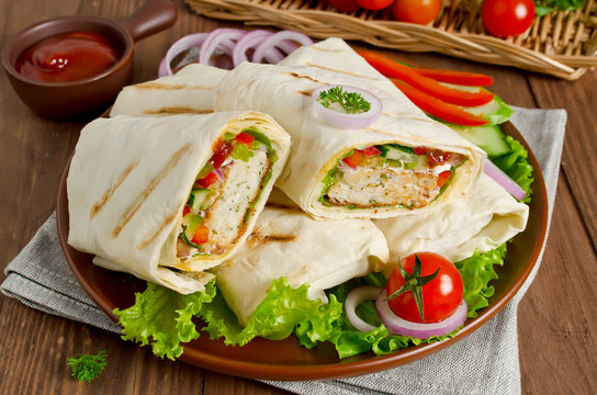 Fresh tortilla wraps with kebab and fresh vegetables on plate