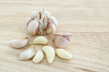 raw garlic on a wooden plank