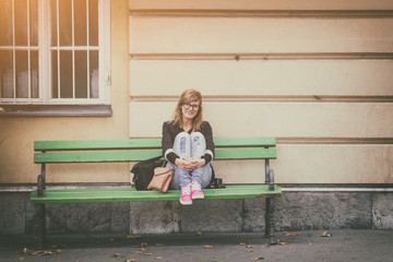 Urban hipster girl posing on a bench.