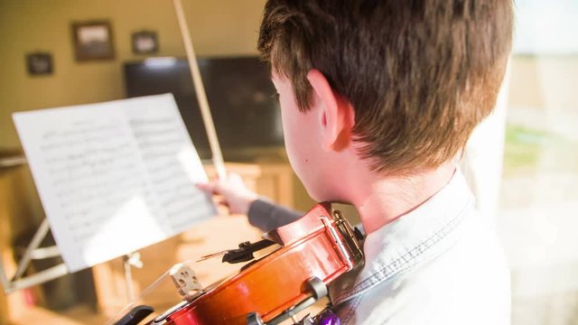 Teenager set up music sheet and start play on violin