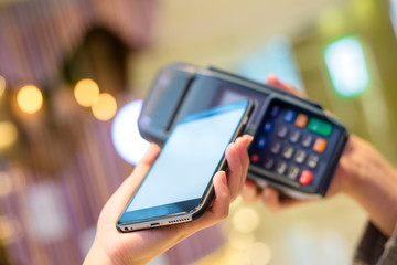 Woman using mobile phone to pay