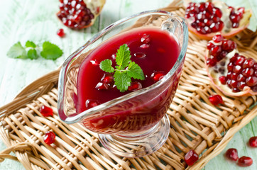 Fresh pomegranate sauce for meat on a wooden table