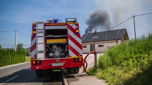 Filling firetruck with water to extinguish nearby fire