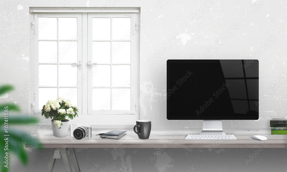 Poster computer with blank screen on office desk. window and white wall in background.