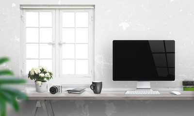 Computer with blank screen on office desk. Window and white wall in background.