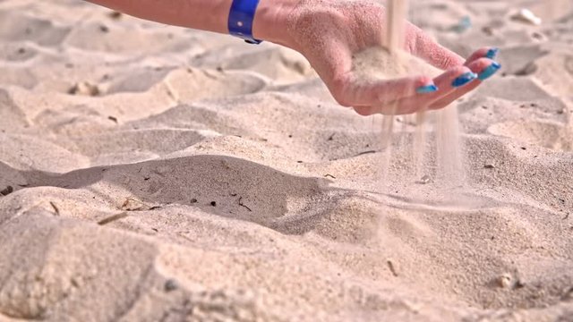 Grabbing sandy beach in palms close up