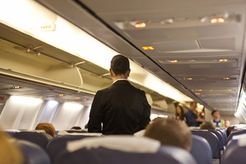 Naklejka premium Interior of airplane with passengers and stewardess walking the aisle