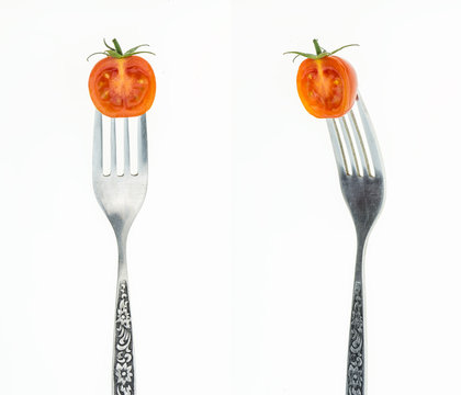 Cherry tomato cut in half on fork, front and side view, on white background. © okolaa