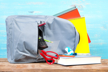 Naklejka premium Backpack with school tools on turquoise background