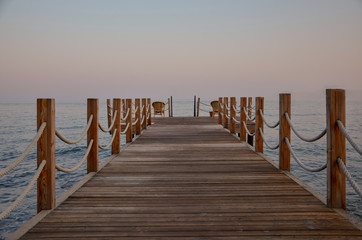Obraz premium wooden pier on the coast of Aegean sea at sunrise Yalikavak bay, Bodrum, Turkey