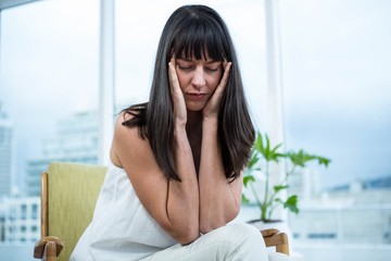 Pregnant woman sitting with headache