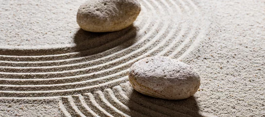  zen zand stilleven - stenen geplaatst over kronkelige golven voor concept van verschillende richtingen of verandering met innerlijke vrede © STUDIO GRAND WEB