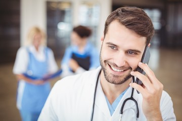 Smiling doctor talking on mobile phone