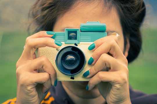 young adult woman with a retro camera