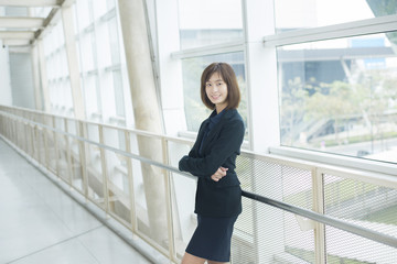 Attractive asian business woman smiling outside office