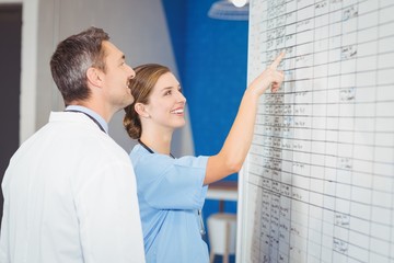 Smiling doctors looking at chart