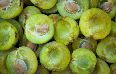 bowl full of different kinds of plums on the healthy green grass