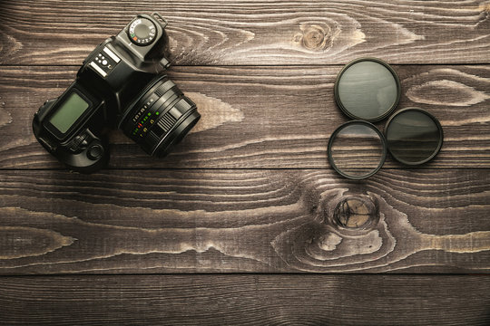 Photo camera on wooden rustic background
