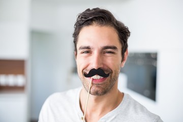 Portrait of smiling man with artificial mustache