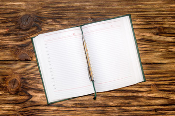 Notepad with pen on wooden table. Top View