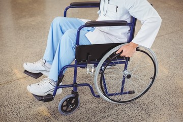 Fototapeta na wymiar Midsection of doctor sitting on wheelchair 