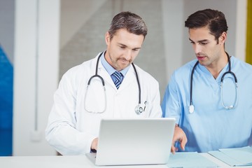 Concentrated doctors working on laptop