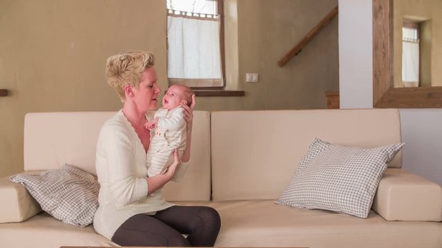 Mother hold baby in hand in big retro living room