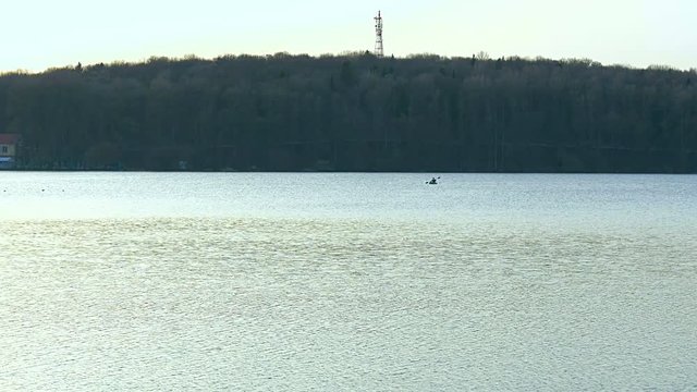 A man rowing in a kayak on the lake