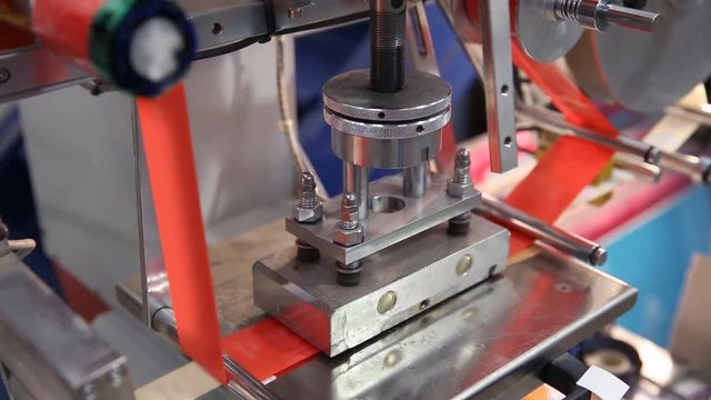 Hot stamping press for printing labels in a red tape ribbon