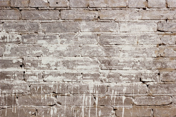 Beige brick wall texture with a paint spot. The background of the brickwork