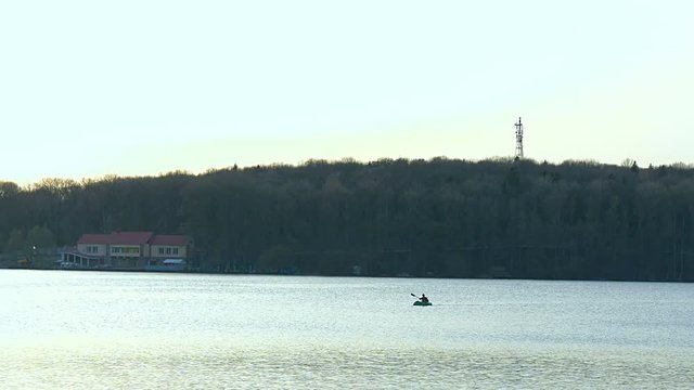 A man rowing in a kayak on the lake