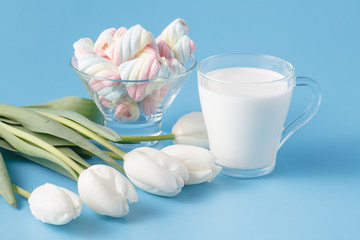glass of fresh milk and tulips