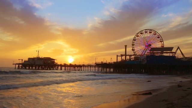 Santa Monica California sunset on Pier Ferris wheel and reflection on beach wet sand