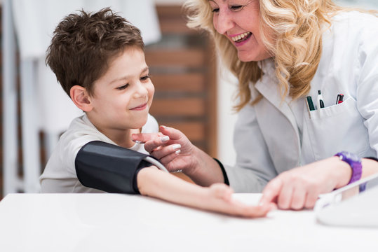 Positive approach to medical examination. Pediatrician and little boy, measuring blood pressure
