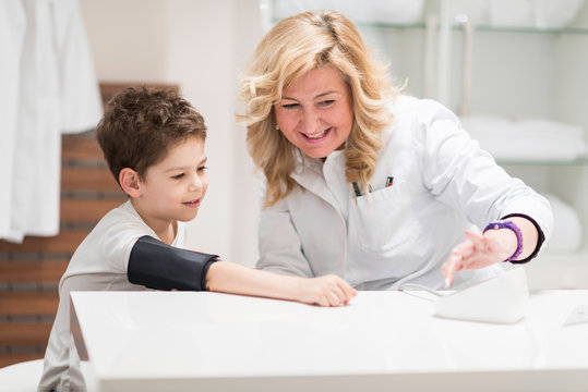 Pediatrician with little boy, measuring blood pressure