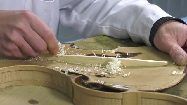 Luthier forms the harmony bar of a violin