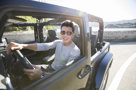 Happy Young Man Driving A Jeep