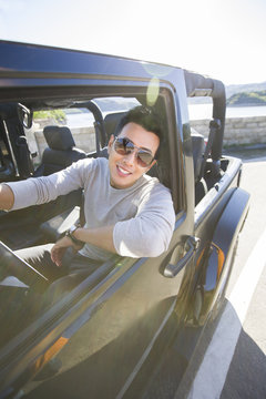 Happy young man driving a jeep