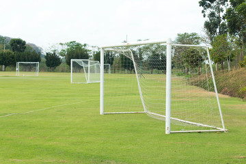 A view of a net on a vacant soccer pitch.