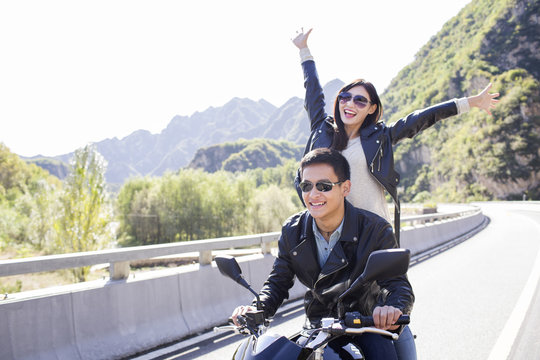 Young couple riding motorcycle together