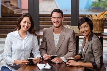 Smiling friends holding a cup of coffee