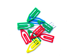 Multi-colored paper clips on a white background.